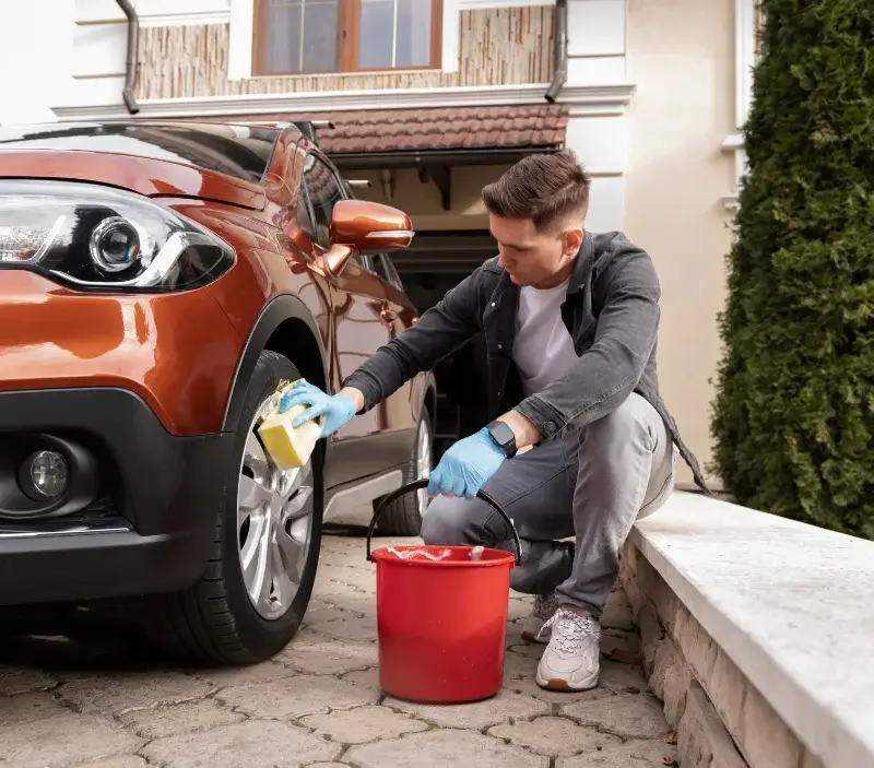 Lavage auto à domicile Saint-Georges-du-Rosay : professionnel intervenant sur un véhicule